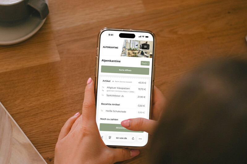 Jemand bezahlt die Restaurantrechnung digital &uuml;ber das Smartphone